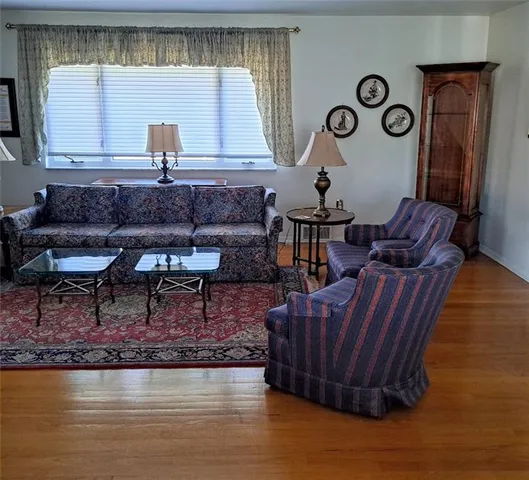 a living room with couches chairs and a large mirror