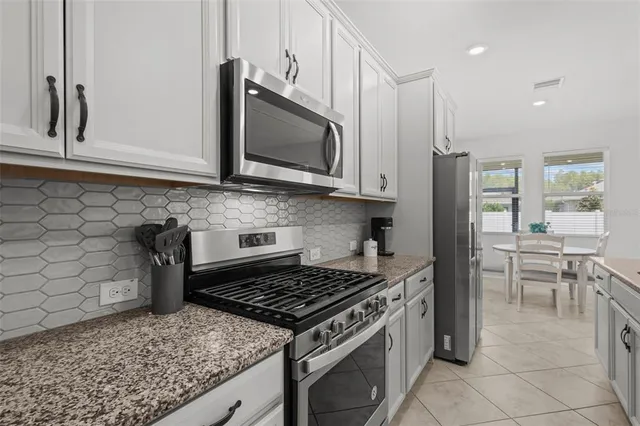 a kitchen with stainless steel appliances granite countertop a stove a microwave and a sink