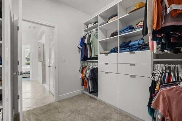 a view of walk in closet with clothes and shoes