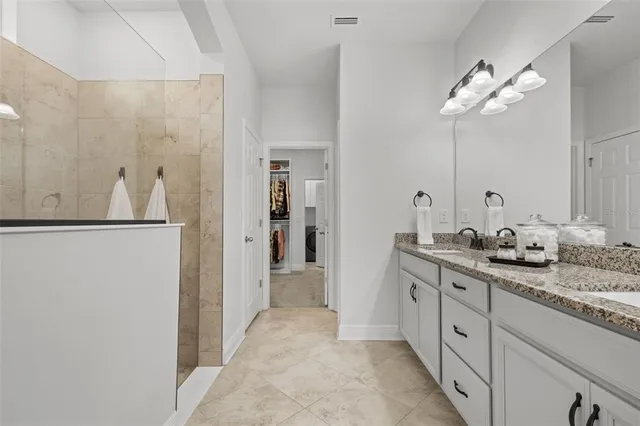 a bathroom with a double vanity sink and mirror with shower