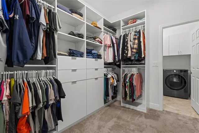 a view of walk in closet with clothes and shoes