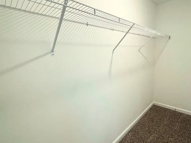 an empty room with a chair and a window