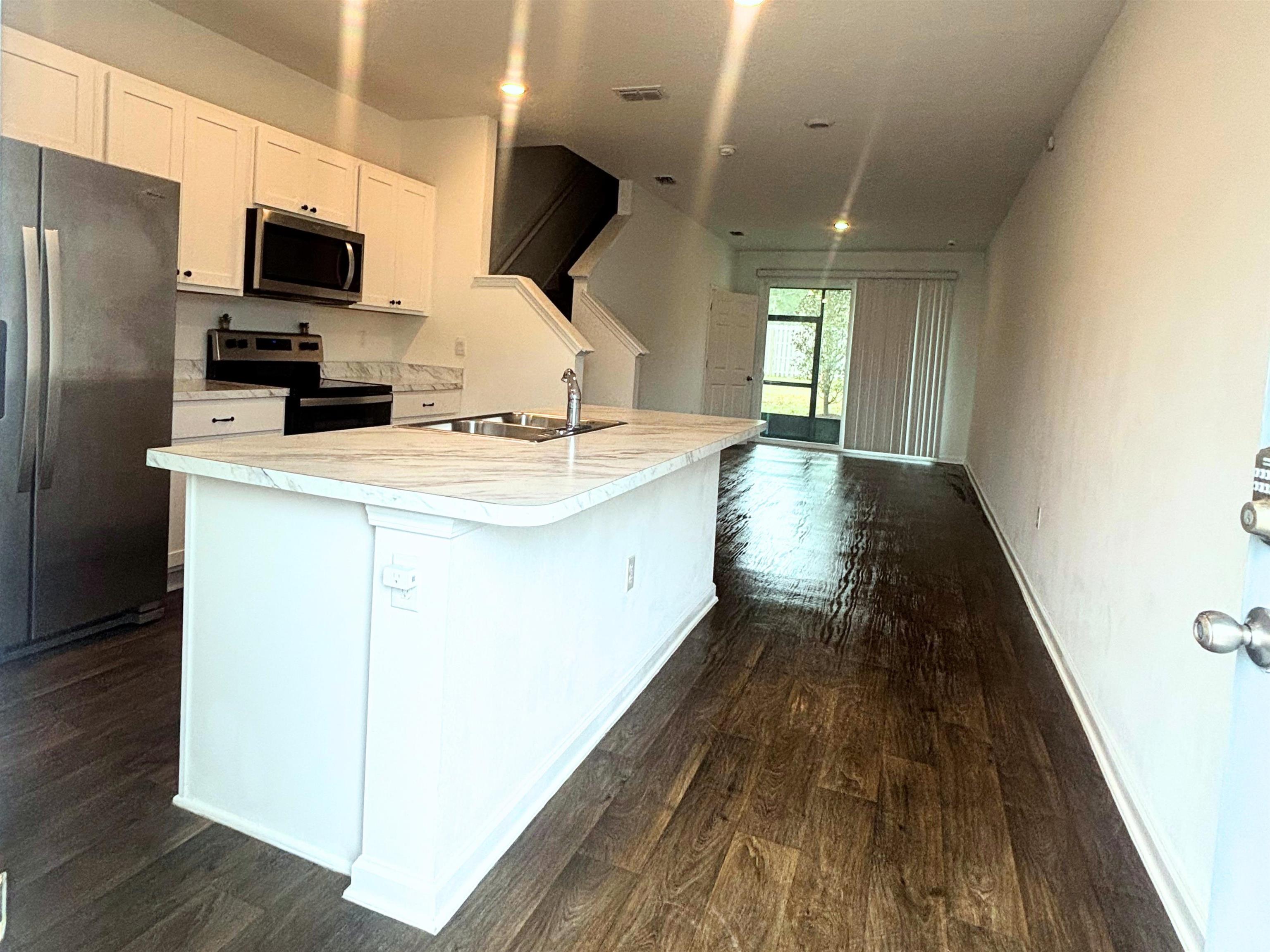 73 Elmhurst Lane St. Augustine, FL 32084 - Photo 3 of 21 a kitchen with kitchen island wooden floors appliances and sink