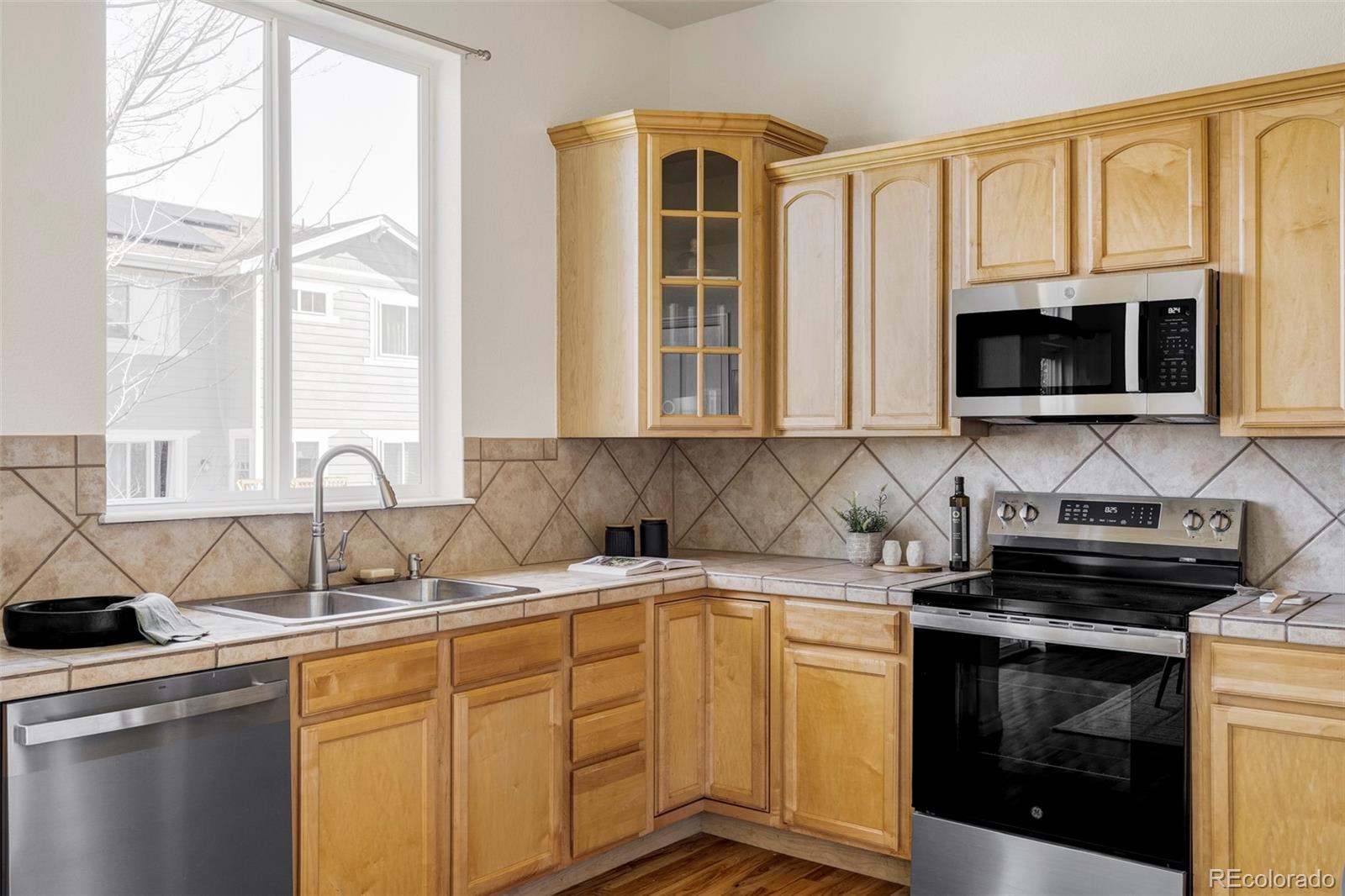 10715 Riverbrook Circle Highlands Ranch, CO 80126 - Photo 8 of 30 a kitchen with stainless steel appliances granite countertop a sink a stove and a microwave