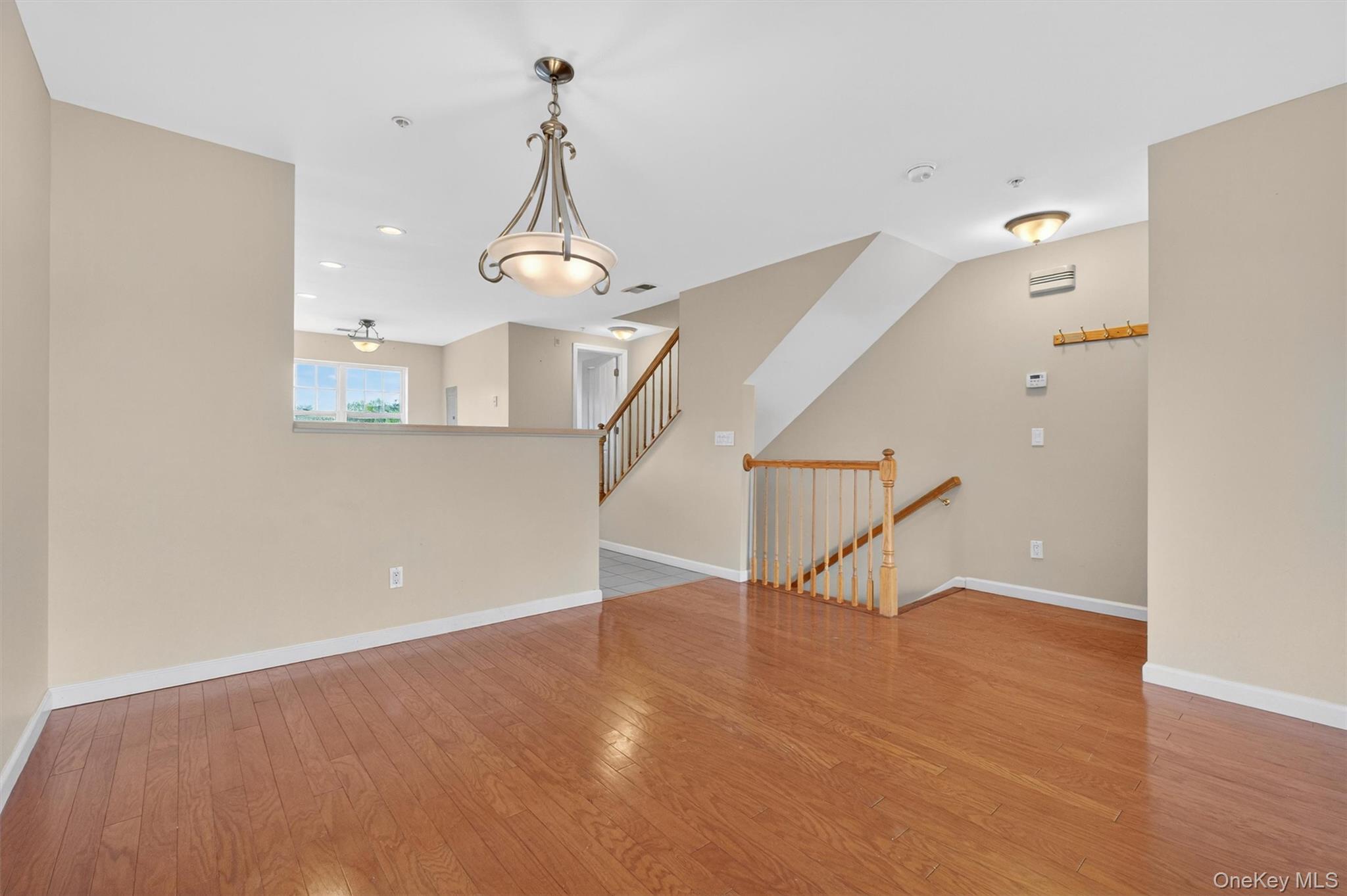 422 Highridge Court, Unit 422 Peekskill, NY 10566 - Photo 12 of 45 At the opposite end of the family room, a spacious formal dining area awaits, highlighted by an elegant chandelier and the same gleaming hardwood floors, flowing seamlessly into the kitchen—perfect for both intimate dinners and entertaining.