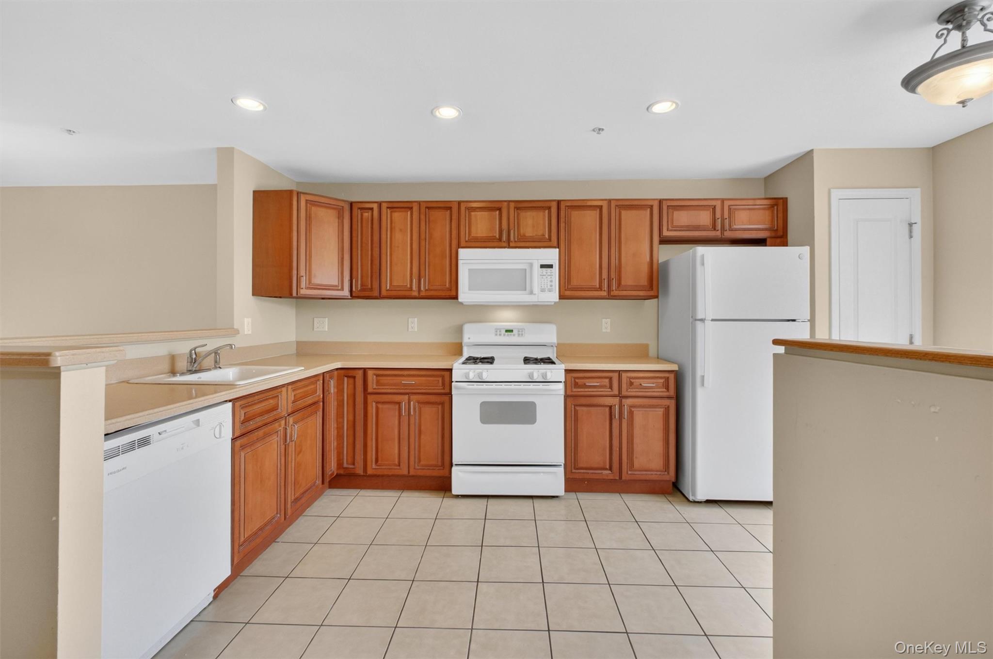 422 Highridge Court, Unit 422 Peekskill, NY 10566 - Photo 15 of 45 The well-appointed kitchen is thoughtfully designed with ample custom cabinetry, white appliances, generous countertops and pantry-flowing seamlessly into the dining area—perfect for meals with a view.