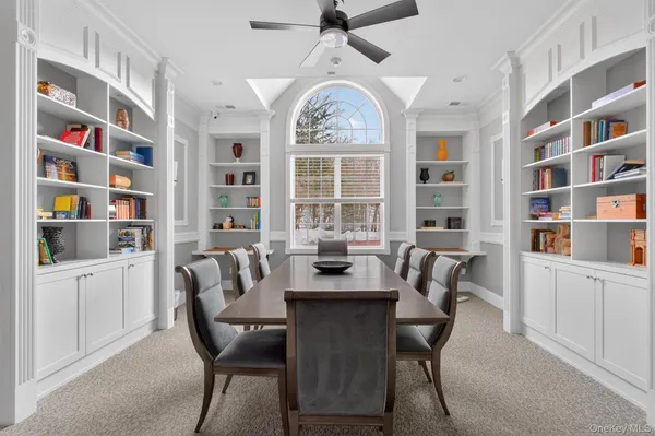 a living room with furniture a dining table and a refrigerator