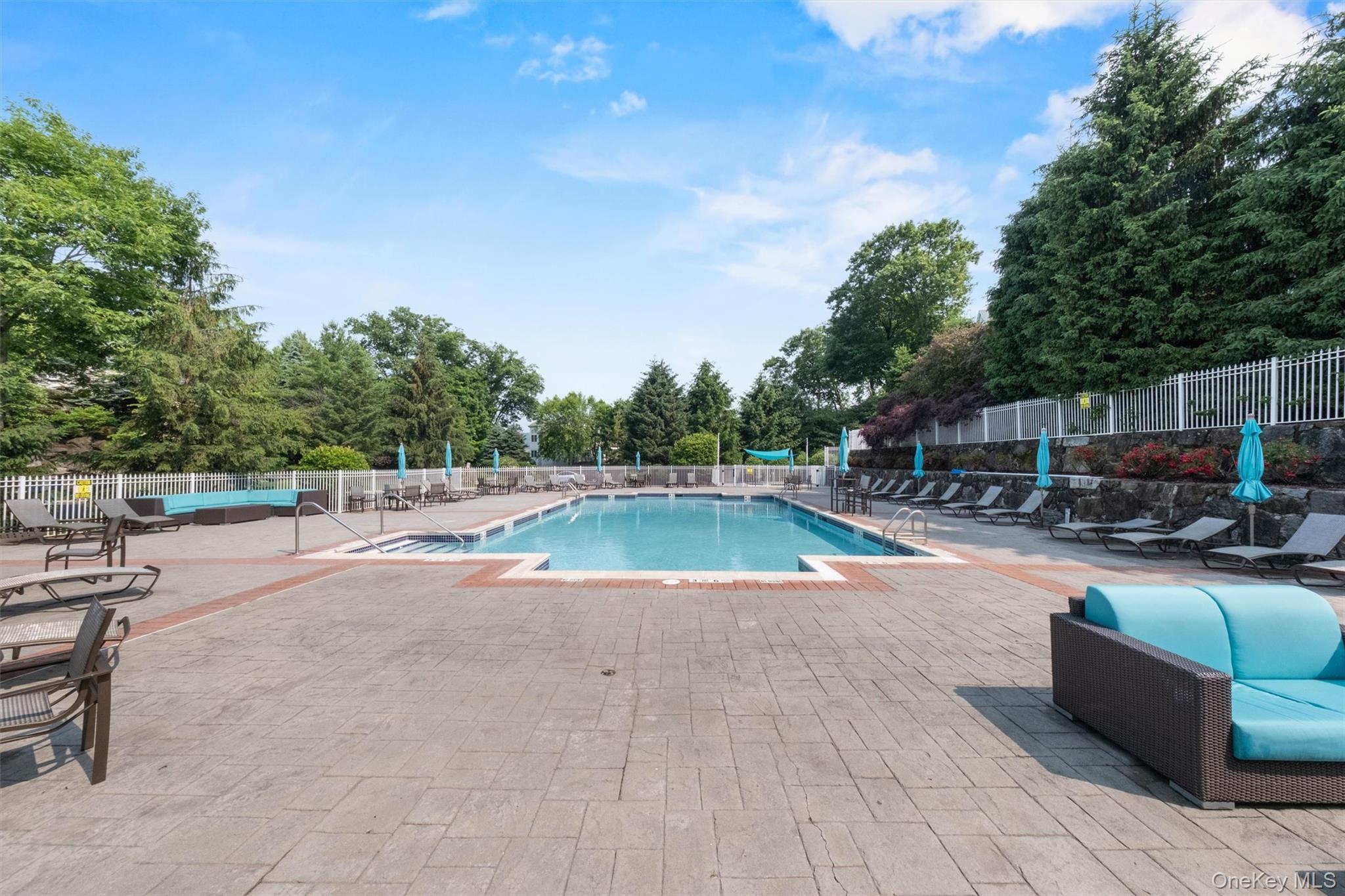 422 Highridge Court, Unit 422 Peekskill, NY 10566 - Photo 44 of 45 The beautifully maintained heated in-ground community pool is a true centerpiece of the Riverbend lifestyle—offering a resort-like escape just steps from your door. Surrounded by expansive sun-drenched patios, this inviting space features an abundance of lounge seating, umbrellas, and areas to relax or socialize. Whether you’re enjoying a refreshing swim, unwinding poolside with a book, or entertaining friends on a warm summer day, the setting is both tranquil and vibrant. Framed by lush greenery and thoughtfully designed for comfort and leisure, this stunning amenity delivers the ultimate blend of relaxation, community, and elevated everyday living.