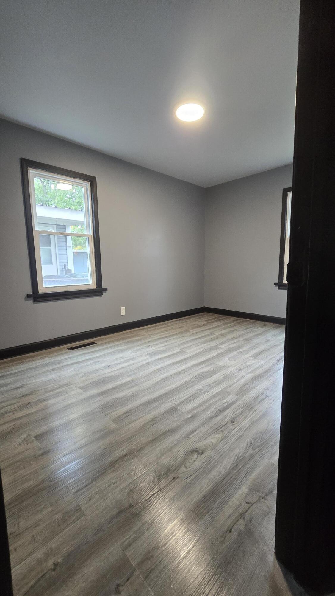 2854 Hancock Street Gary, IN 46405 - Photo 1 of 13 an empty room with wooden floor and windows
