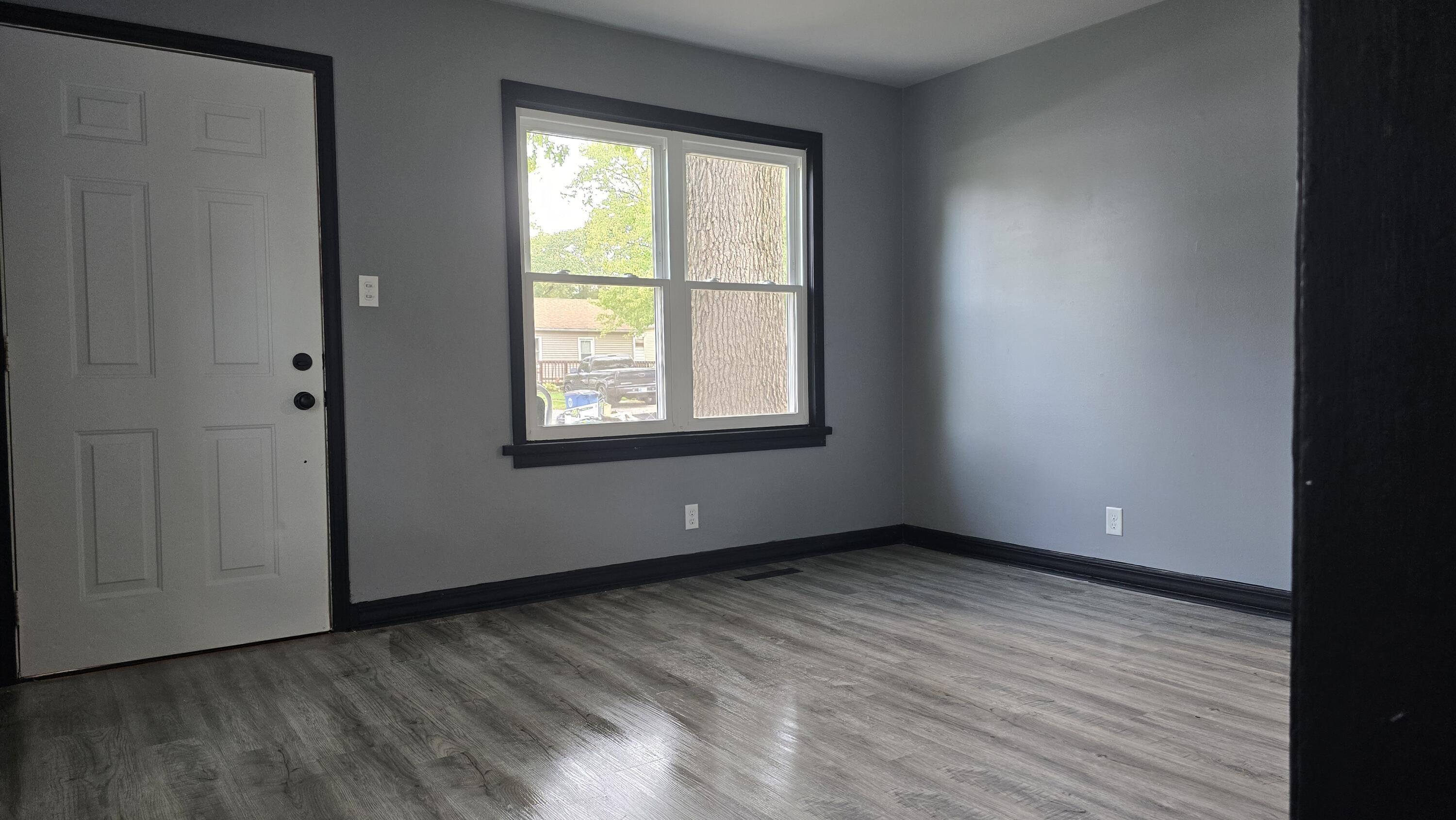 2854 Hancock Street Gary, IN 46405 - Photo 2 of 13 an empty room with wooden floor and windows