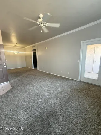 a view of an empty room with a chandelier fan