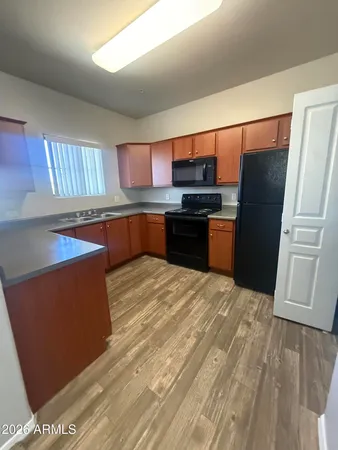 a kitchen with stainless steel appliances granite countertop a refrigerator a stove a sink and a microwave