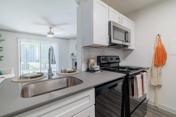 a kitchen with stainless steel appliances granite countertop a sink stove and microwave