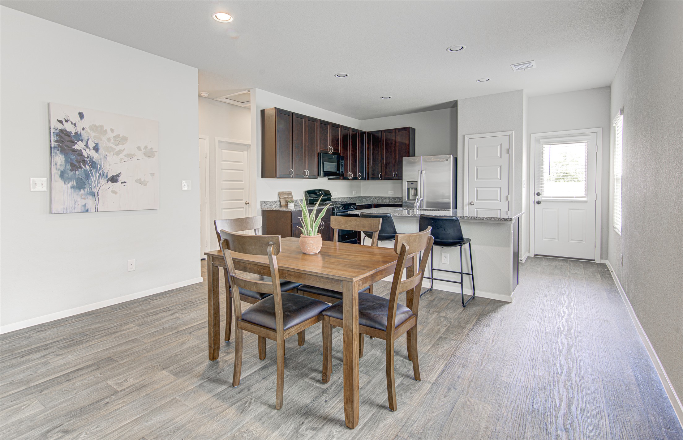 156 Tillage Road Elgin, TX 78621 - Photo 11 of 25 An open-concept living space integrates a well-appointed kitchen with a comfortable dining area, perfect for daily meals.