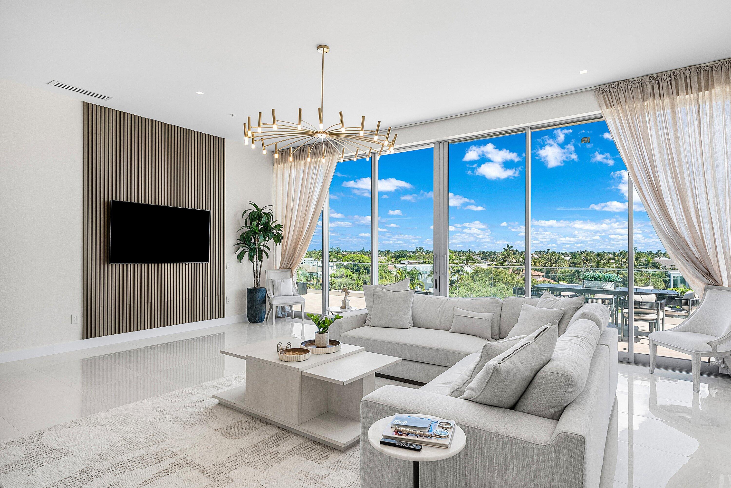 246 Northeast 6th Avenue, Unit PH Delray Beach, FL 33483 - Photo 11 of 36 a living room with furniture a flat screen tv and a large window