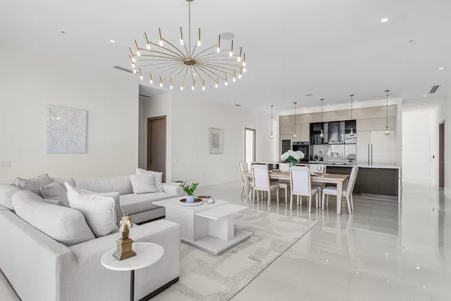 a living room with furniture dining table and a chandelier