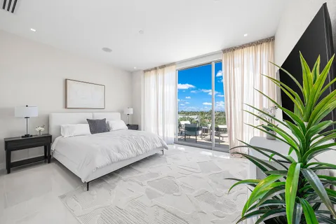 a spacious bedroom with a large bed and a potted plant