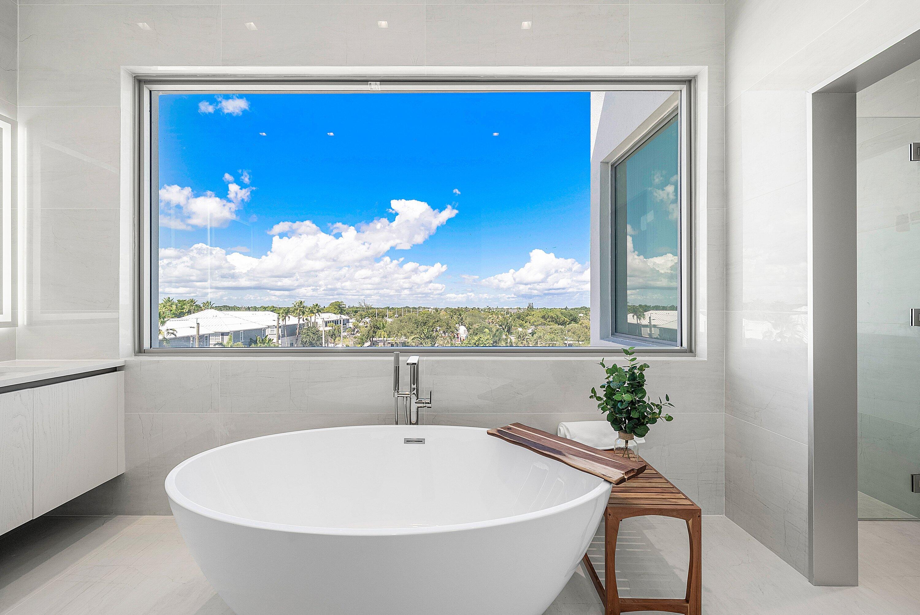 246 Northeast 6th Avenue, Unit PH Delray Beach, FL 33483 - Photo 22 of 36 a bathroom with a bathtub and mirror