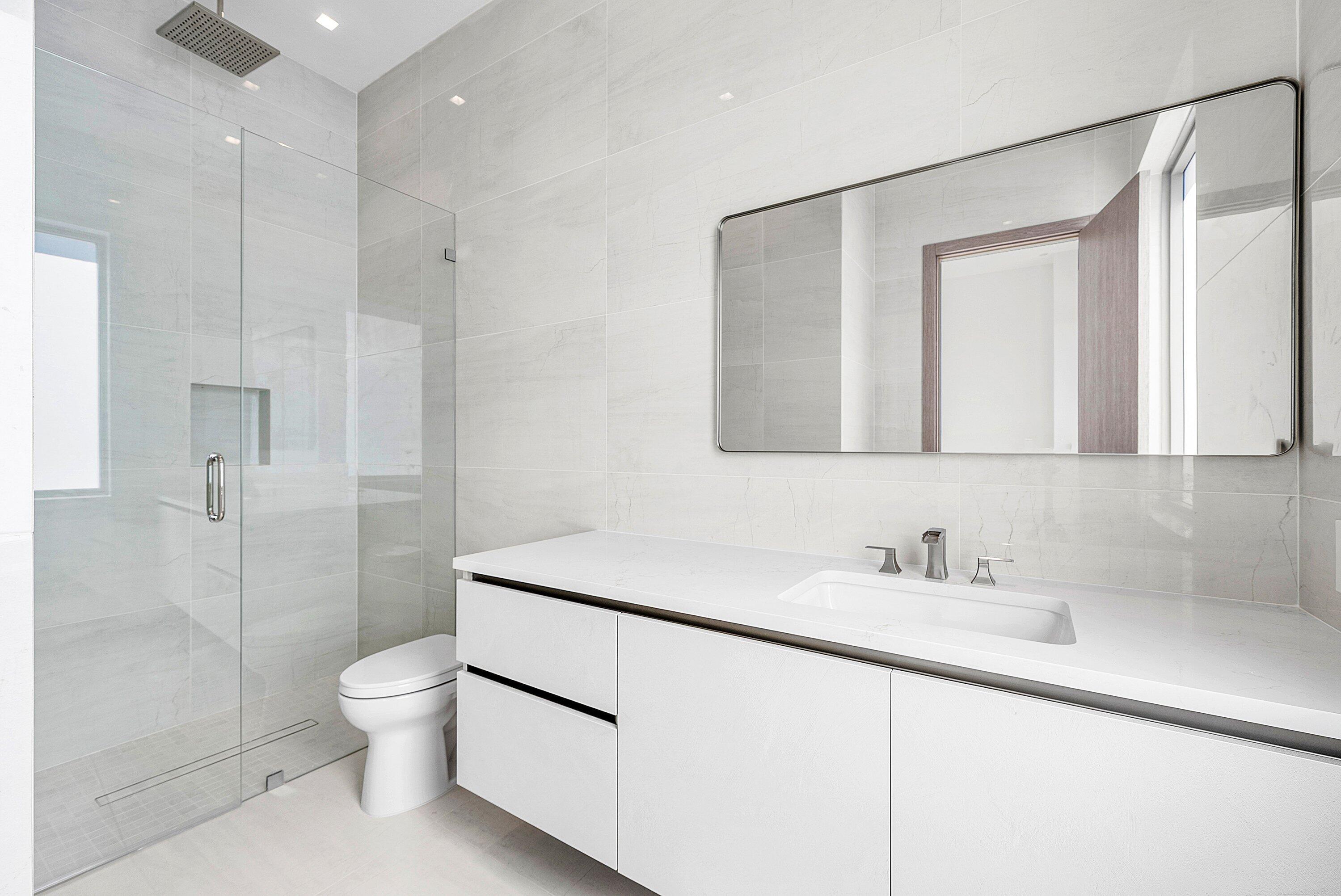 246 Northeast 6th Avenue, Unit PH Delray Beach, FL 33483 - Photo 28 of 36 a bathroom with a toilet sink and shower