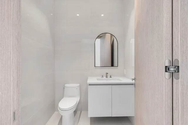 a bathroom with a toilet sink and mirror