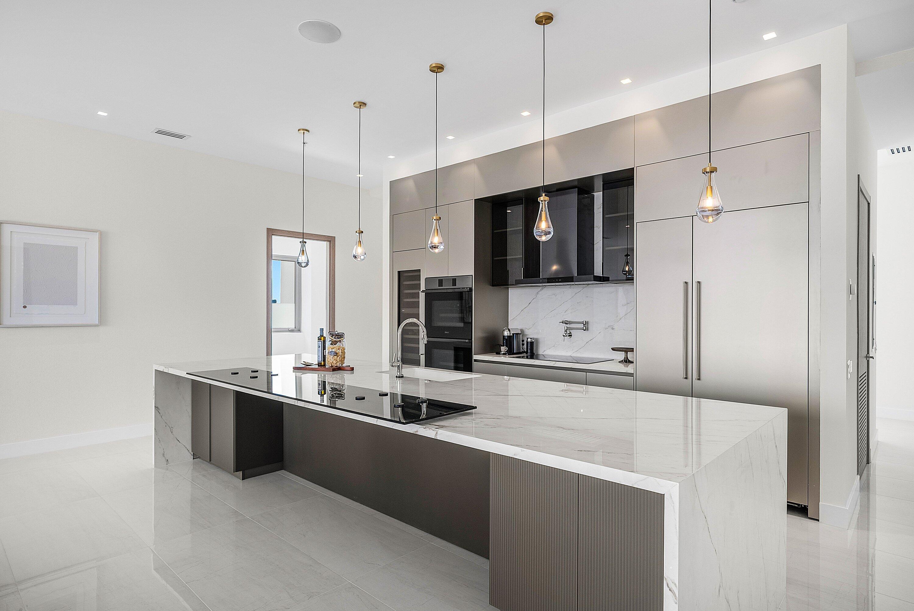 246 Northeast 6th Avenue, Unit PH Delray Beach, FL 33483 - Photo 4 of 36 a large kitchen with kitchen island a sink stainless steel appliances and cabinets