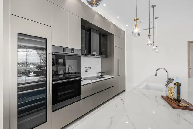 a kitchen with stainless steel appliances kitchen island granite countertop a stove and a refrigerator