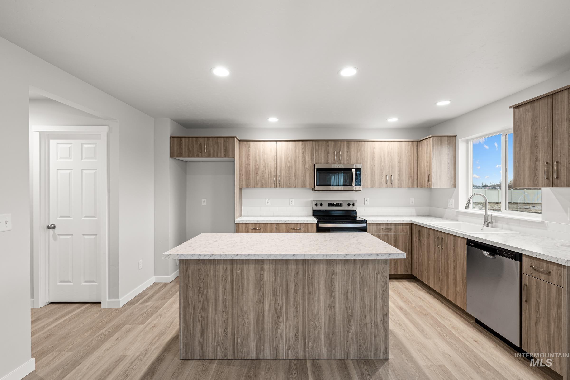 13693 Redway Court Caldwell, ID 83607 - Photo 3 of 25 Kitchen featuring stainless steel appliances, light countertops, a kitchen island, light wood-style floors, and recessed lighting