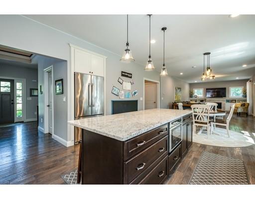 320 West Acton Road Stow, MA 01775 - Photo 10 of 39 a kitchen with stainless steel appliances kitchen island granite countertop a table chairs and a wooden floor