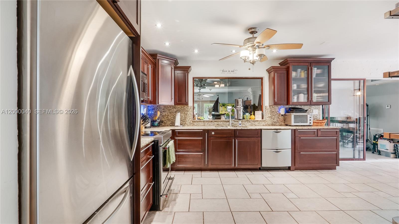 4020 Southwest 2nd Street Plantation, FL 33317 - Photo 25 of 43 a kitchen with kitchen island granite countertop a refrigerator oven a sink dishwasher and a stove with wooden floor
