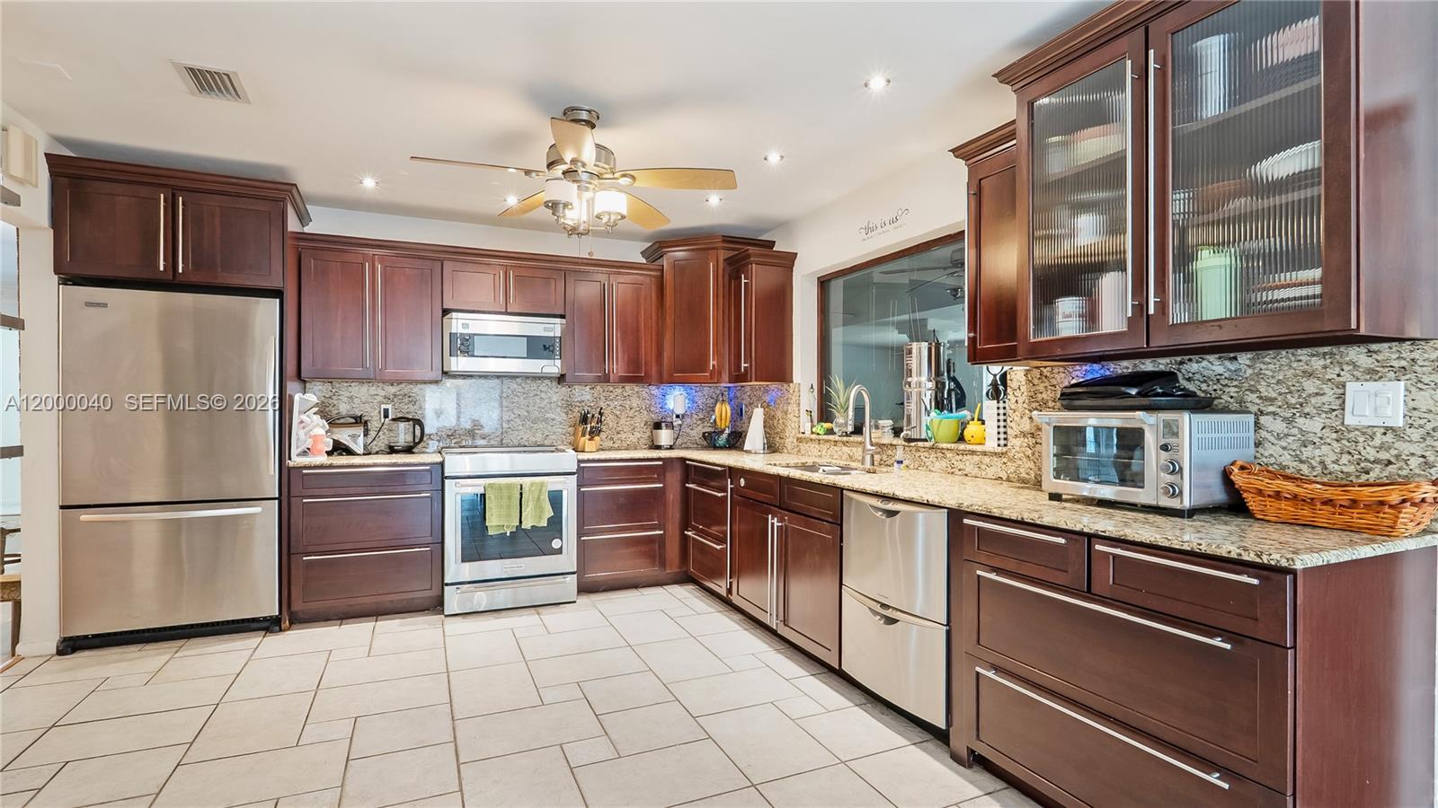 4020 Southwest 2nd Street Plantation, FL 33317 - Photo 27 of 43 a kitchen with stainless steel appliances granite countertop a refrigerator and a stove top oven