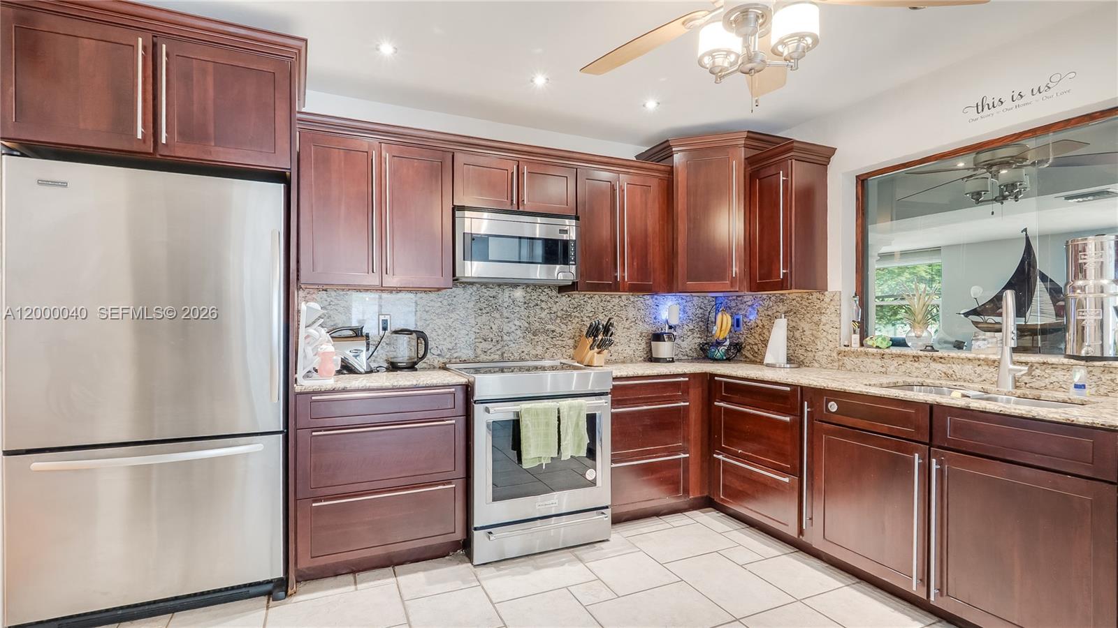 4020 Southwest 2nd Street Plantation, FL 33317 - Photo 28 of 43 a kitchen with stainless steel appliances granite countertop a refrigerator sink and cabinets