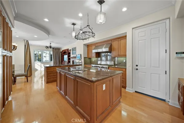 a kitchen with stainless steel appliances granite countertop a sink a stove and a refrigerator