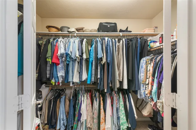 a view of walk in closet with clothes