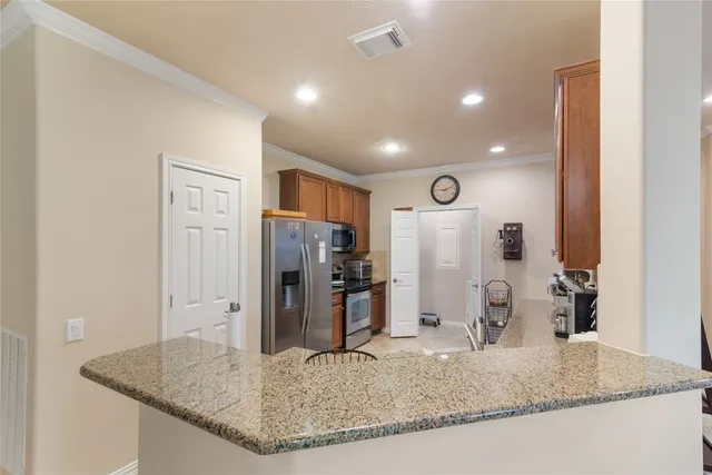 a view of kitchen island a sink dishwasher and refrigerator with wooden floor