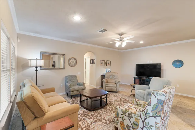a living room with furniture a flat screen tv and a chandelier
