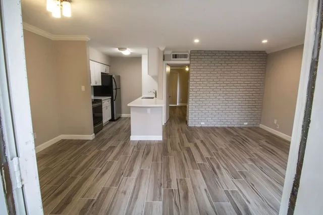 a view of empty room with wooden floor