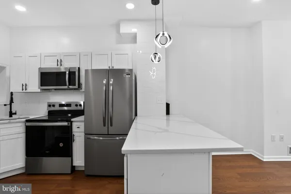 a kitchen with stainless steel appliances a refrigerator sink and microwave