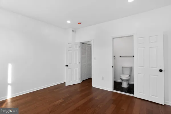 a view of empty room with wooden floor and white wall