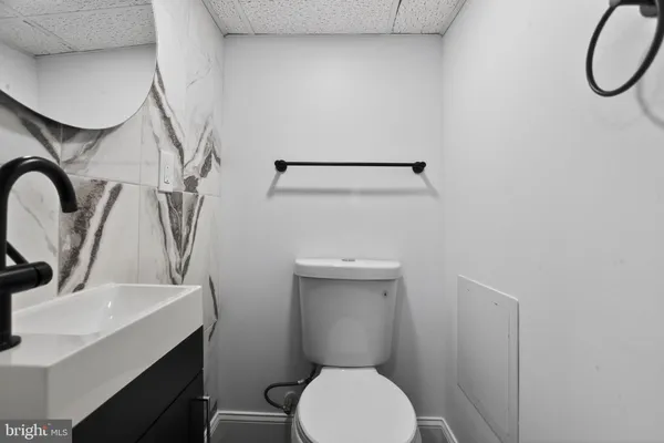 a bathroom with a sink a toilet and a mirror