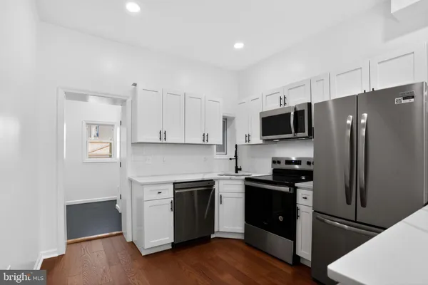 a kitchen with a refrigerator stove and wooden cabinets