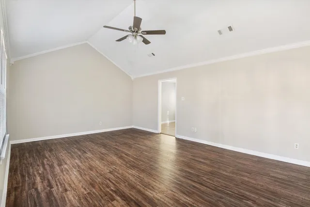 a view of an empty room with wooden floor
