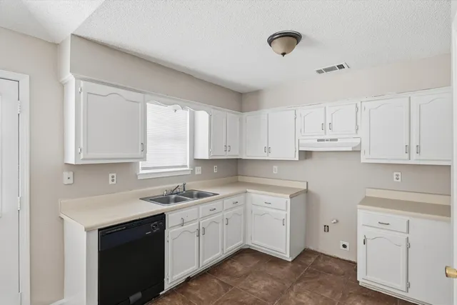 a kitchen with cabinets appliances a sink and a window