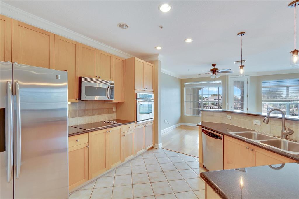6414 Sunset Bay Circle Apollo Beach, FL 33572 - Photo 14 of 52 a kitchen with stainless steel appliances granite countertop a sink and a refrigerator