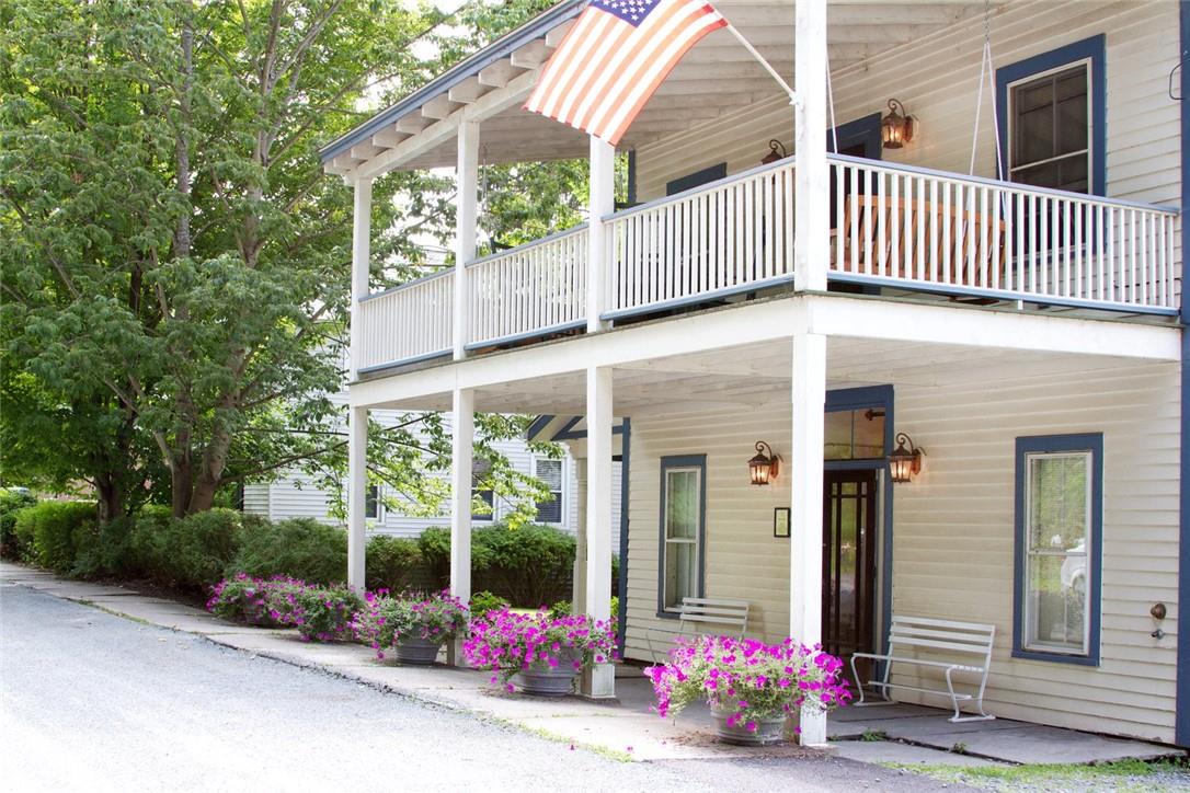 View of exterior entry with a balcony and covered porch