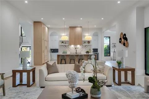 a living room with furniture and a view of kitchen