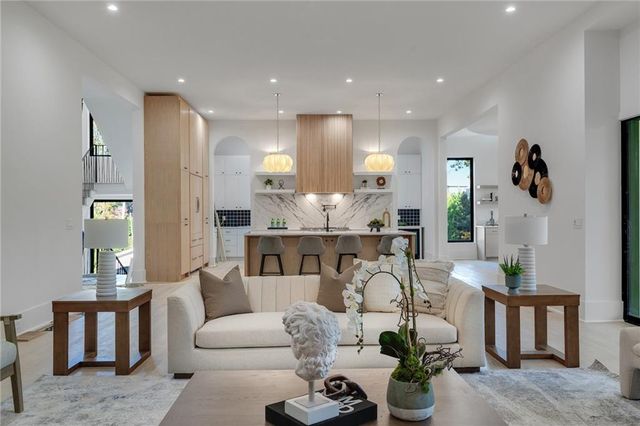a living room with furniture and a view of kitchen
