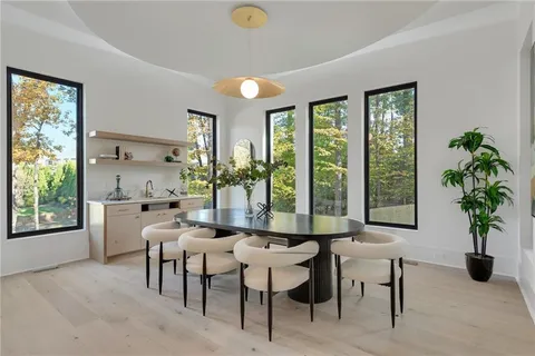 a dining room with furniture and large windows