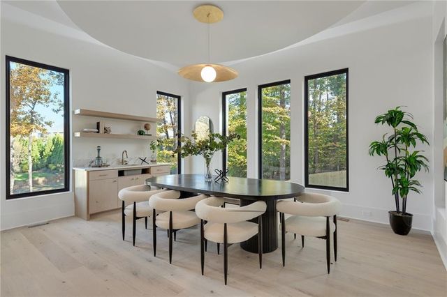 a dining room with furniture and large windows