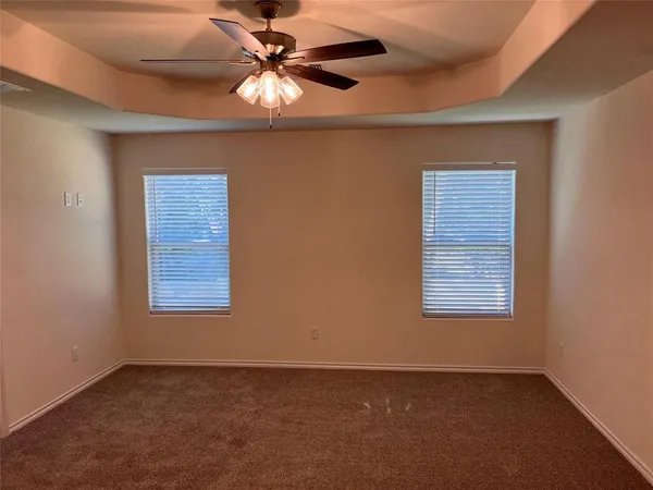 an empty room with a window and a fan