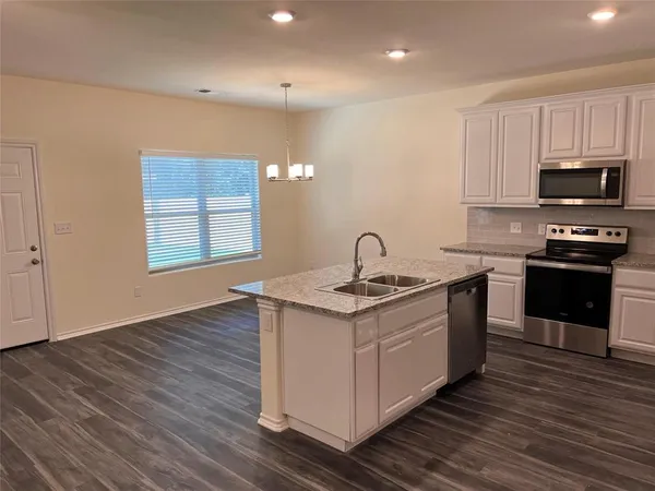 a kitchen with a sink and steel appliances